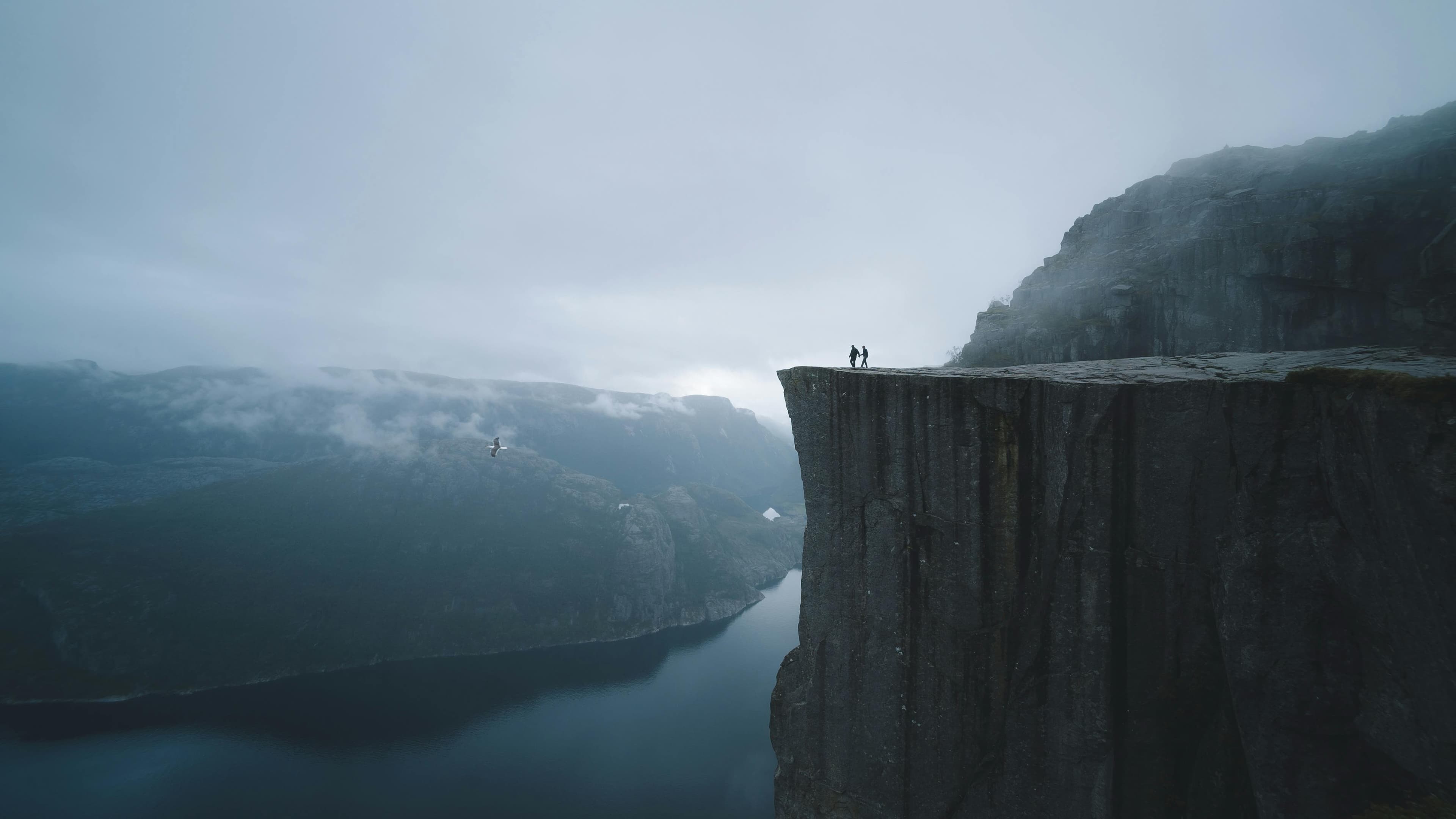 Preikestolen i Norge — to personer på klippen over Lysefjorden